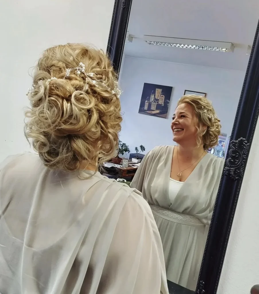 Blonde Locken-Hochsteckfrisur im Spiegel bei Friseur ist Kopfsache