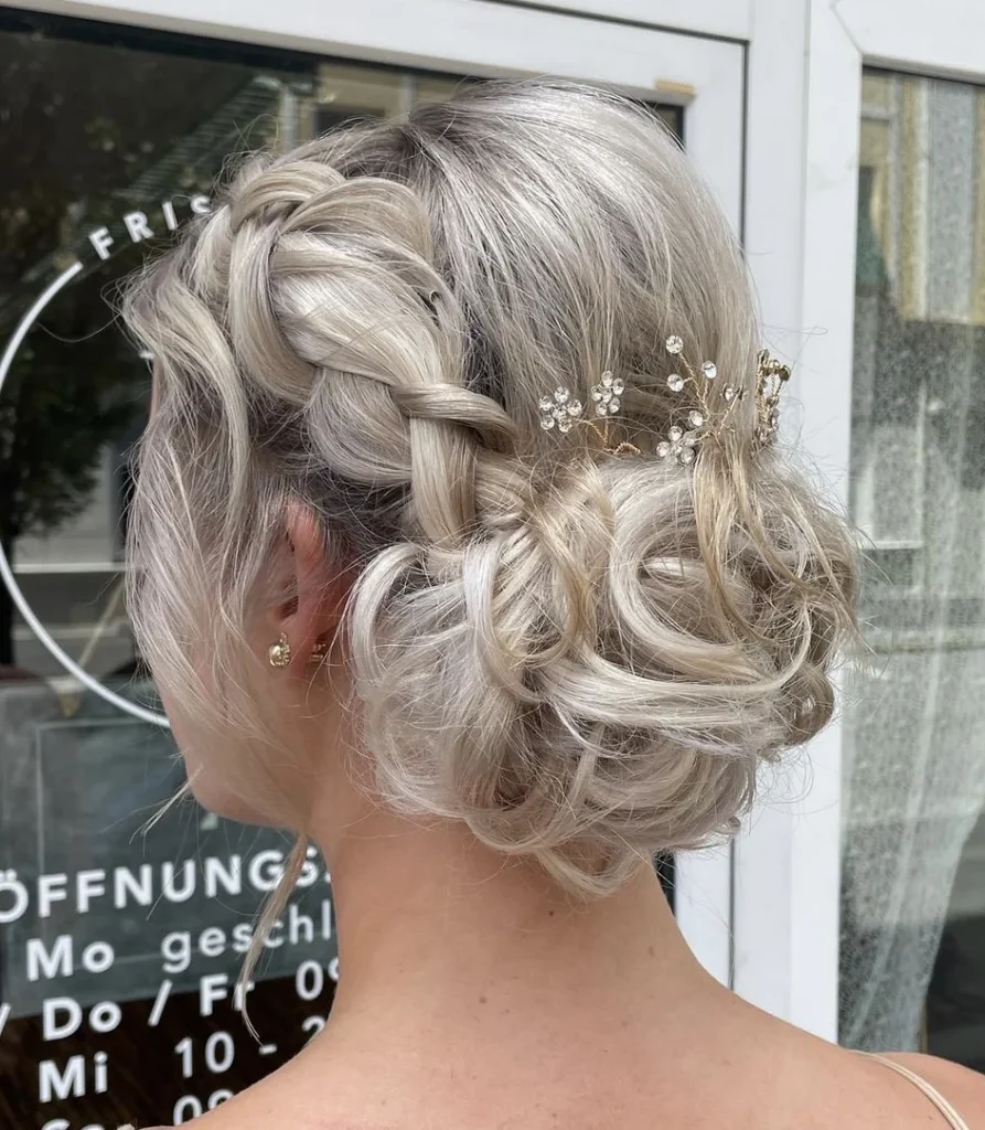 Blonde Brautfrisur mit Flechtelementen und Perlen von der Seite