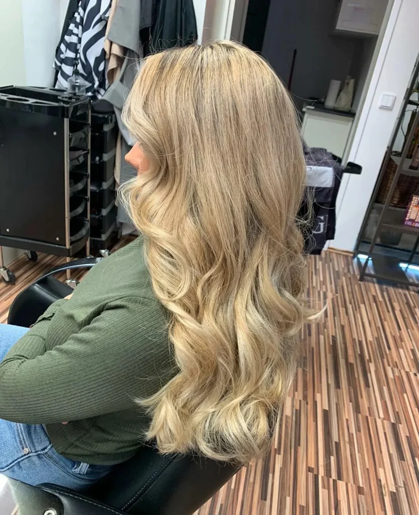 Lange blonde Wellen im Salon von Friseur ist Kopfsache