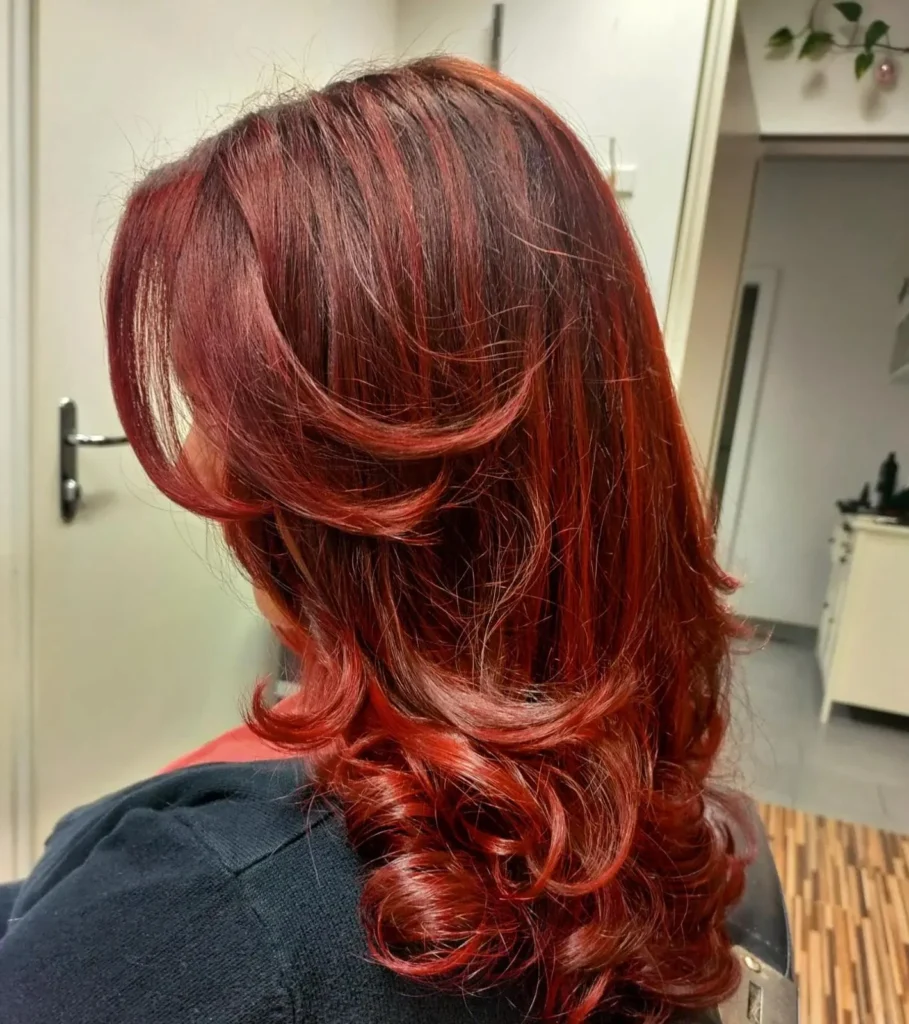 Rote Locken mit stufigem Schnitt bei Friseur ist Kopfsache